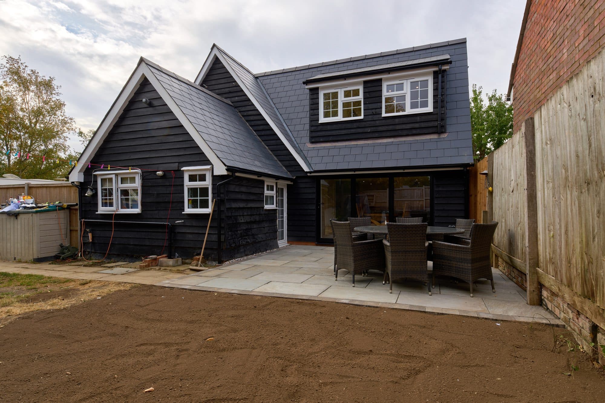 The finished rear of the cottage with the new extension and stone patio by DNR Build