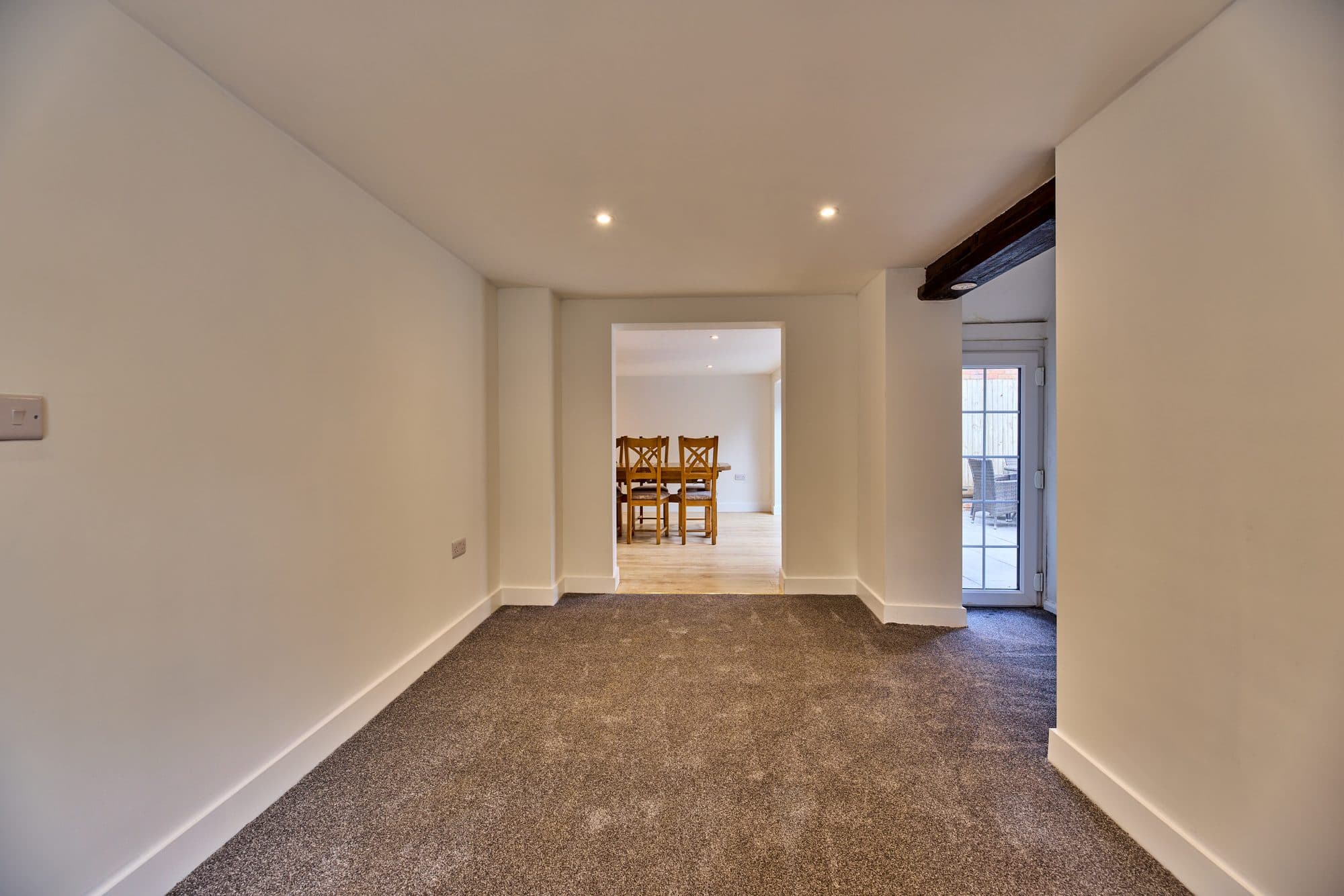 The bright renovated living room opening through to the new dining room by DNR Build