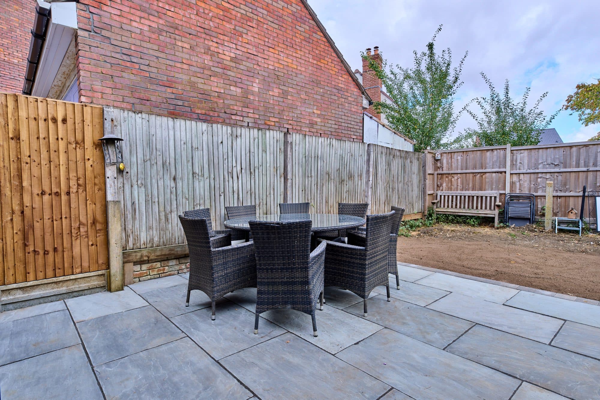 The new stone patio with an outdoor dining set by DNR Build