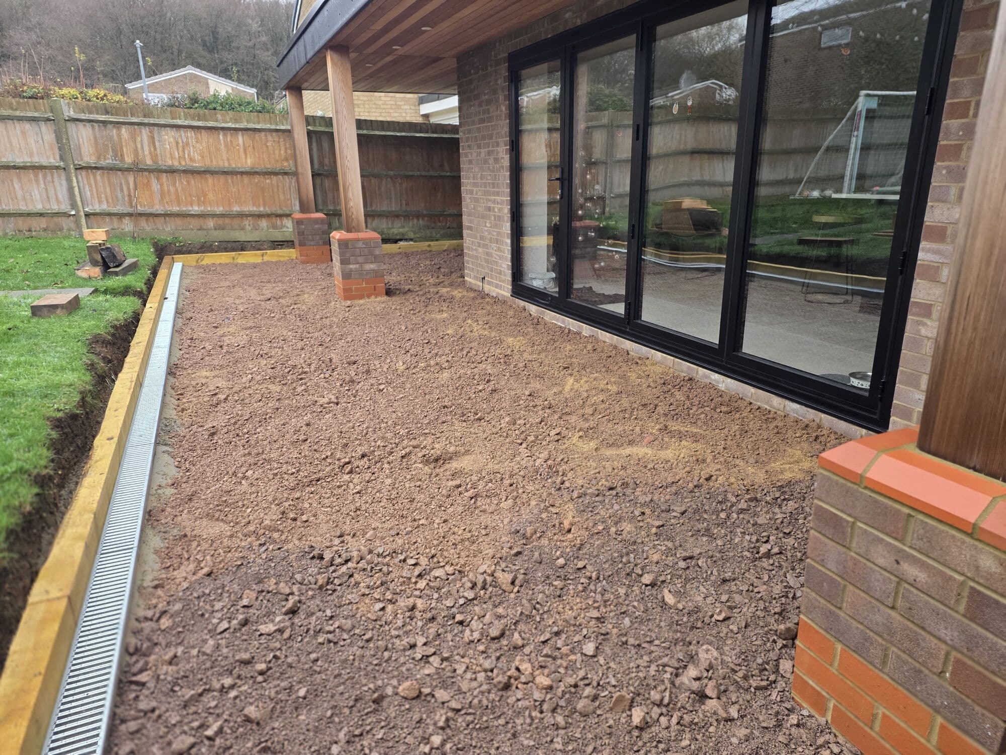 Bare ground beside the bi-fold doors before the patio went down