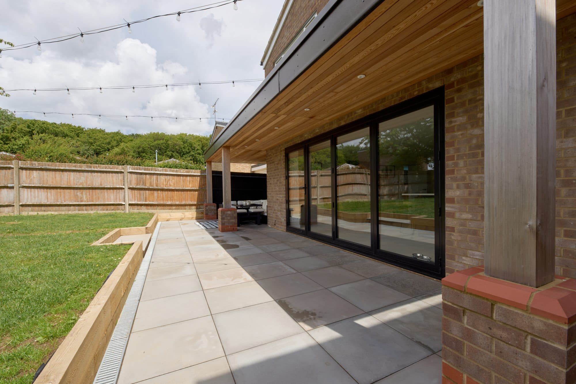 The finished large format patio with a drainage channel and sleeper edging by DNR Build