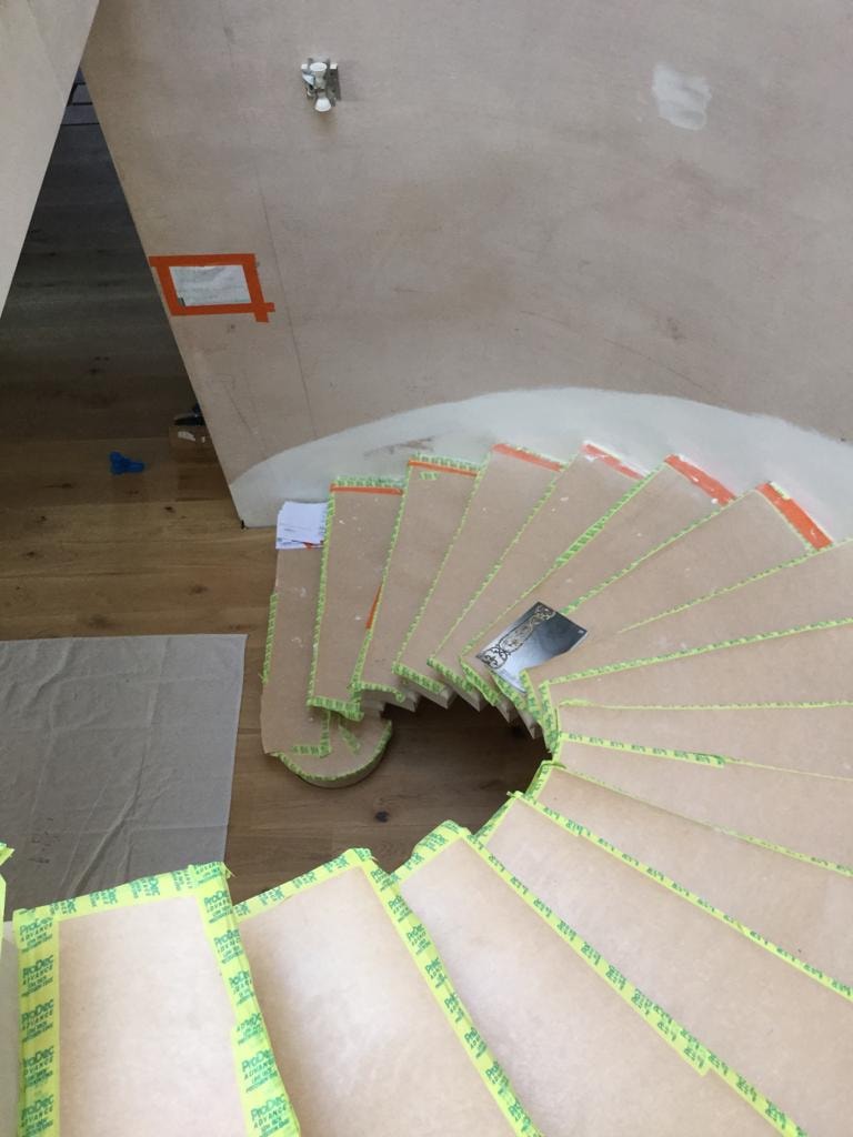 Bespoke sweeping staircase under construction with protected treads inside the country house by DNR Build