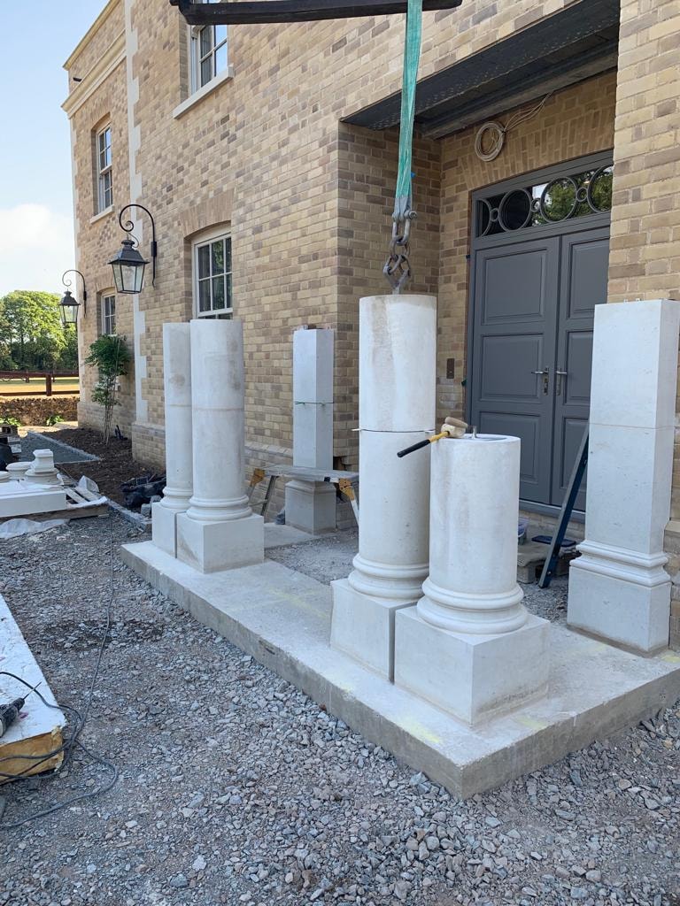 Natural stone column being craned into position at the portico entrance by DNR Build