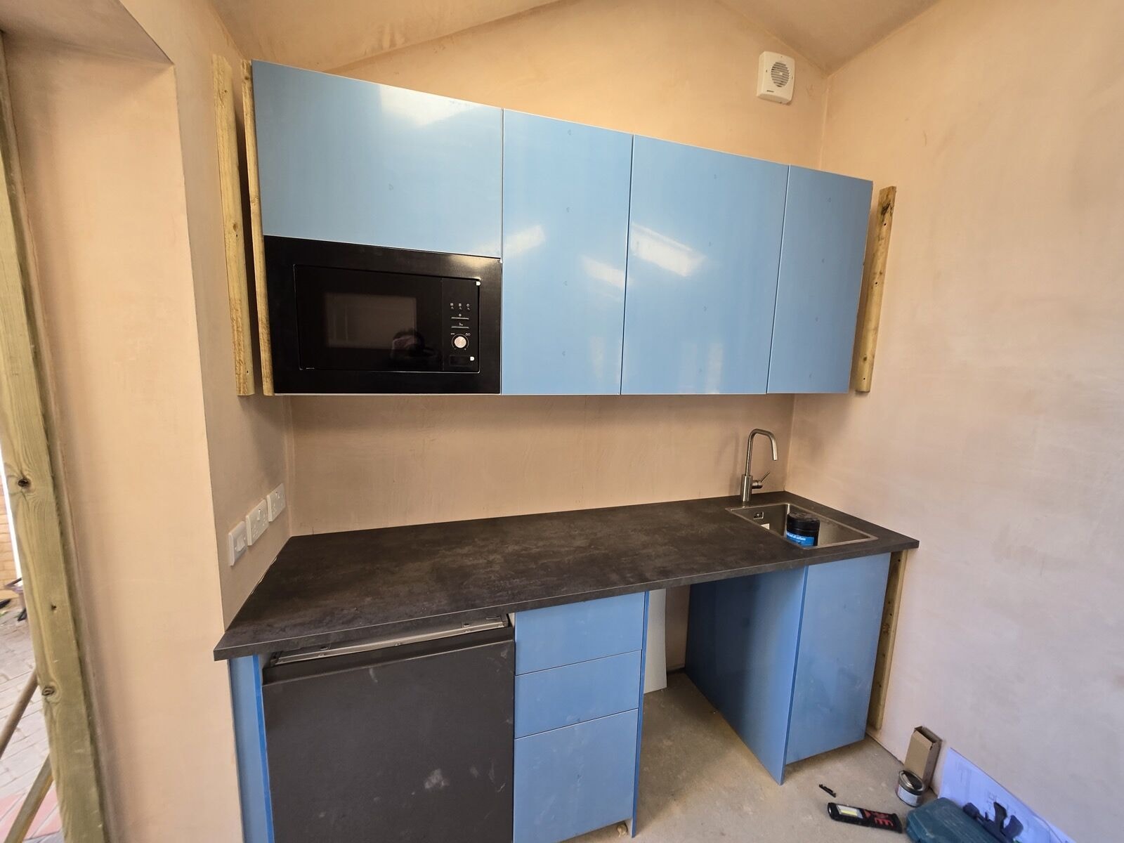 Annexe kitchenette being fitted with blue gloss units during the project by DNR Build