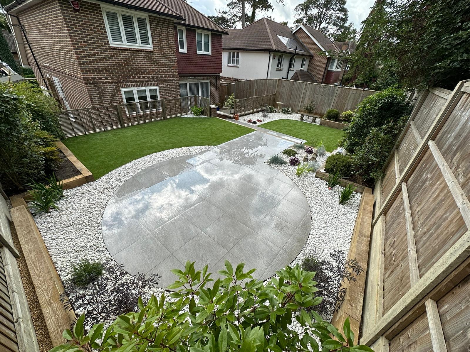 The completed garden design with the circular patio, curved lawn and white pebble beds by DNR Build