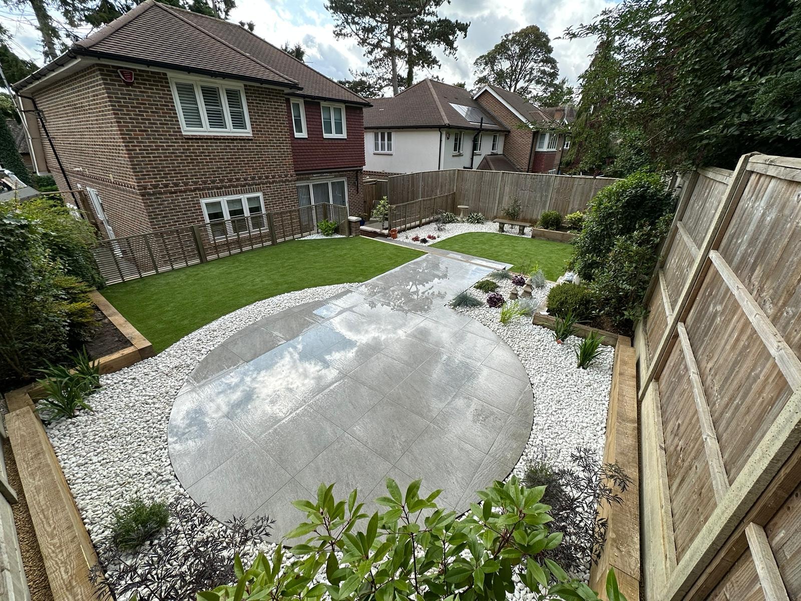 White pebble border with slate and feature planting beside the shaped lawn by DNR Build