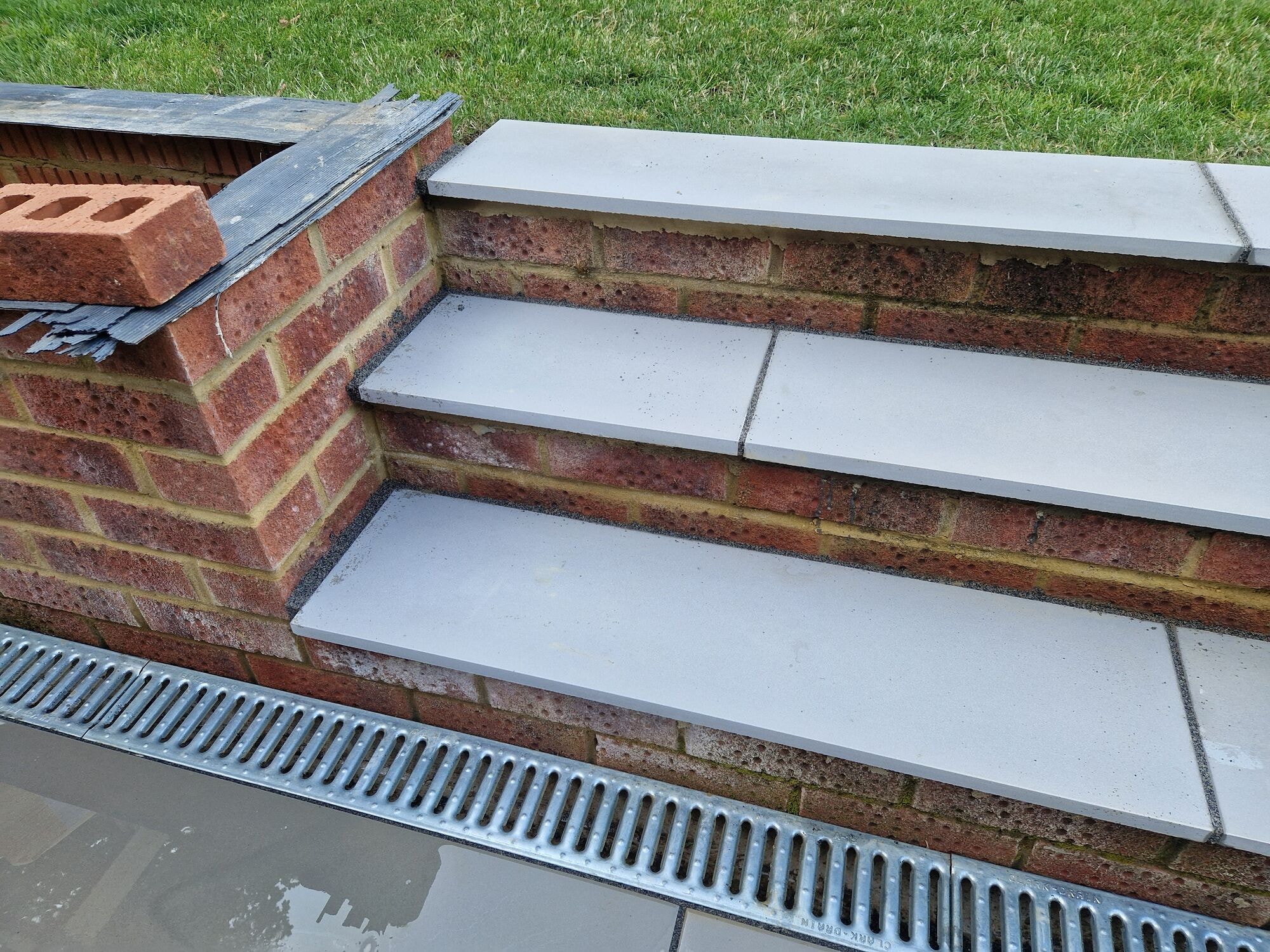 Detail of the new brick steps with porcelain treads in the finished garden by DNR Build