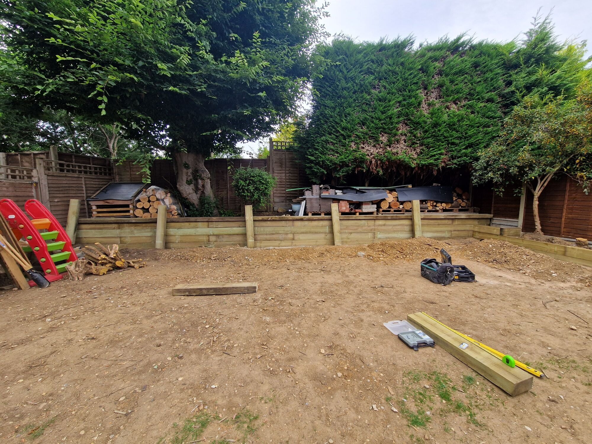 Sleeper retaining wall and levelled ground taking shape during the garden revamp by DNR Build