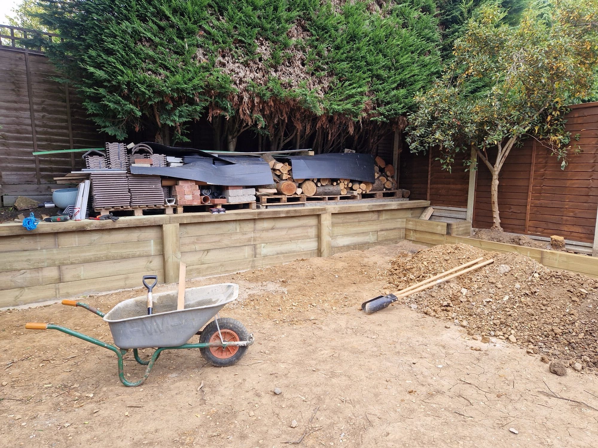 Routed back sleeper retaining wall with the dug out garden ready for the new patio by DNR Build