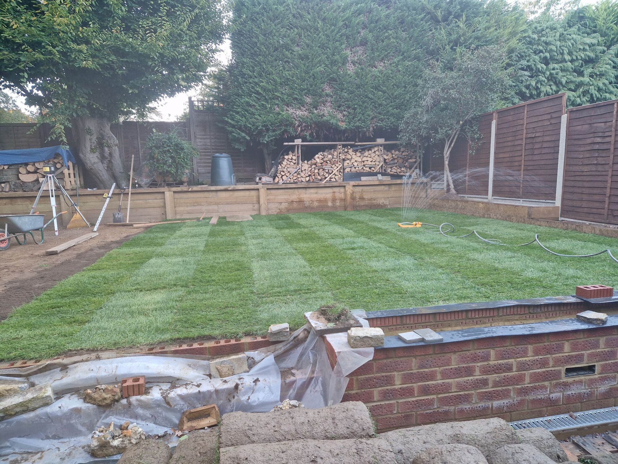 More turf laid and watered in, with the striped new lawn taking shape by DNR Build