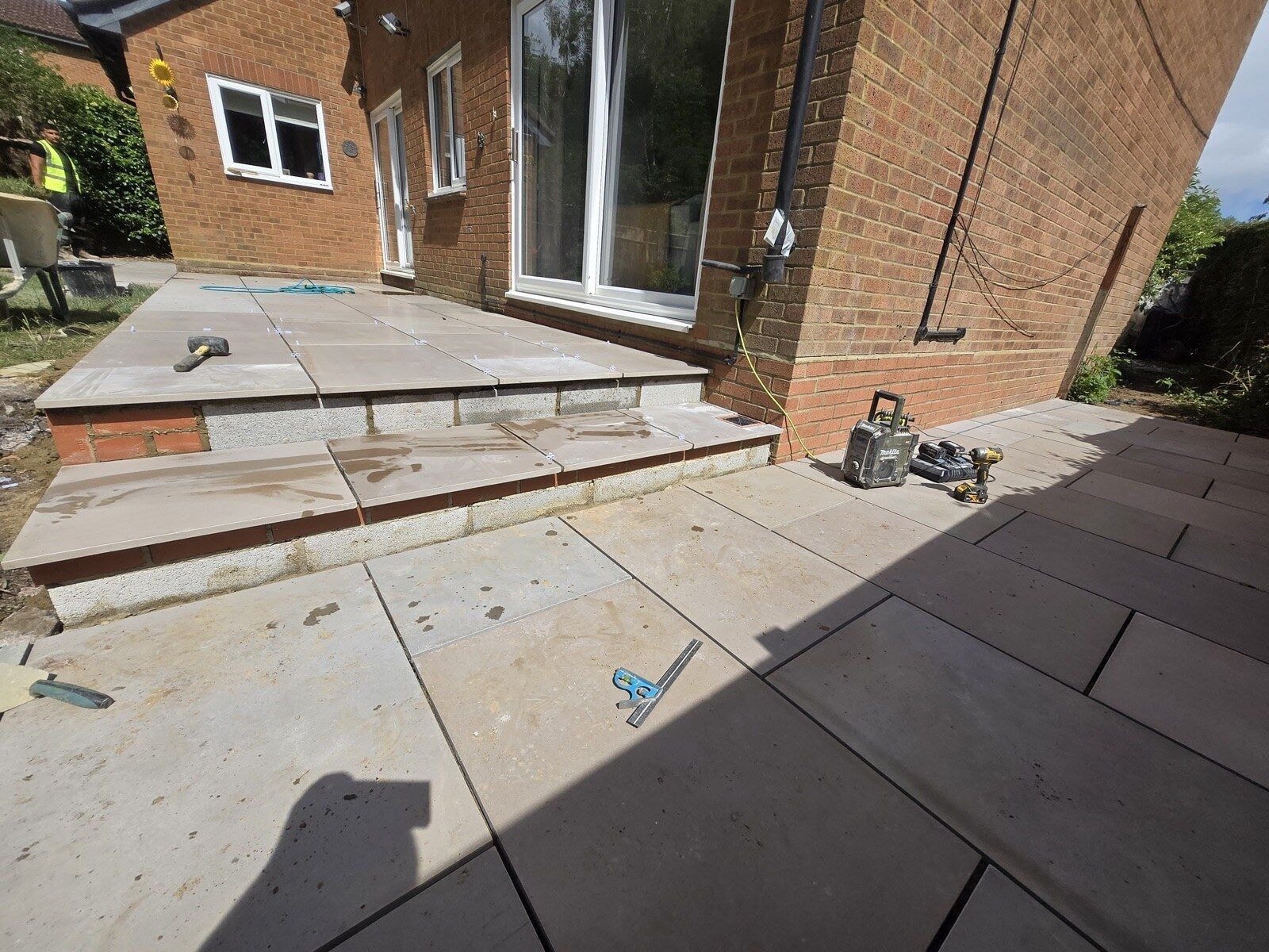 Wide view along the freshly laid sandstone patio beside the house by DNR Build