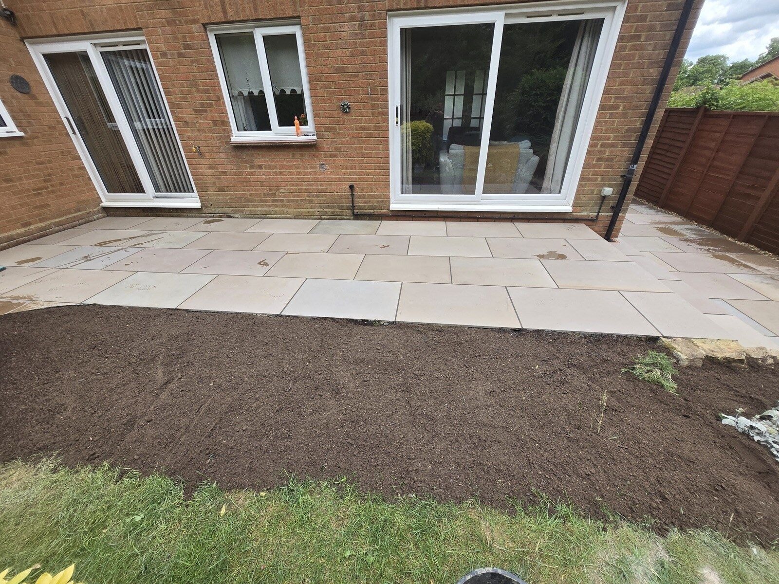 Completed sandstone patio across the rear of the house with the lawn area prepared by DNR Build