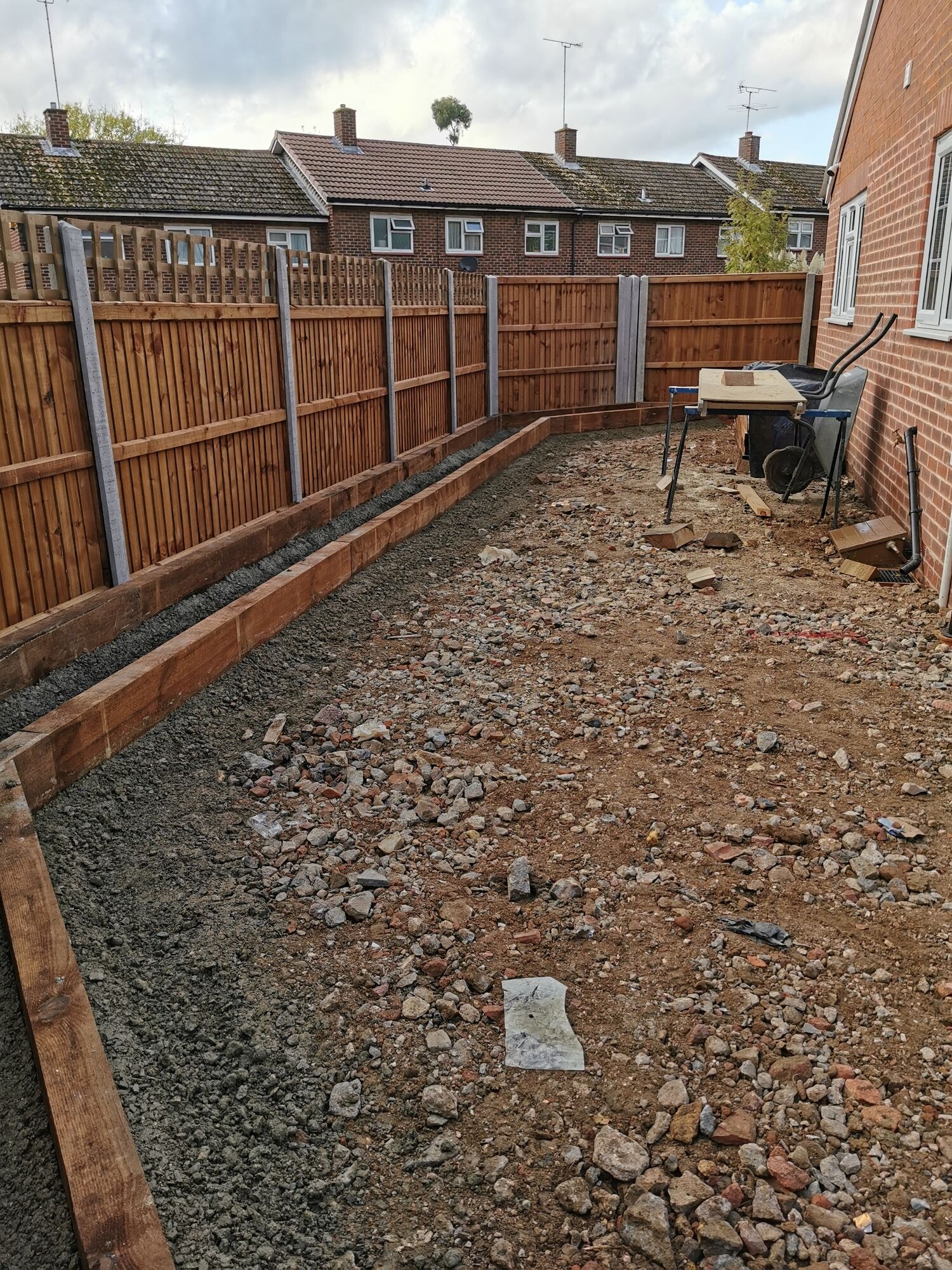 New oak sleeper retaining beds set into concrete along the garden boundary by DNR Build