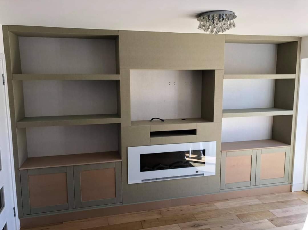 Bespoke floor to ceiling media unit with open shelving, base cupboards and a TV and fire recess by DNR Build