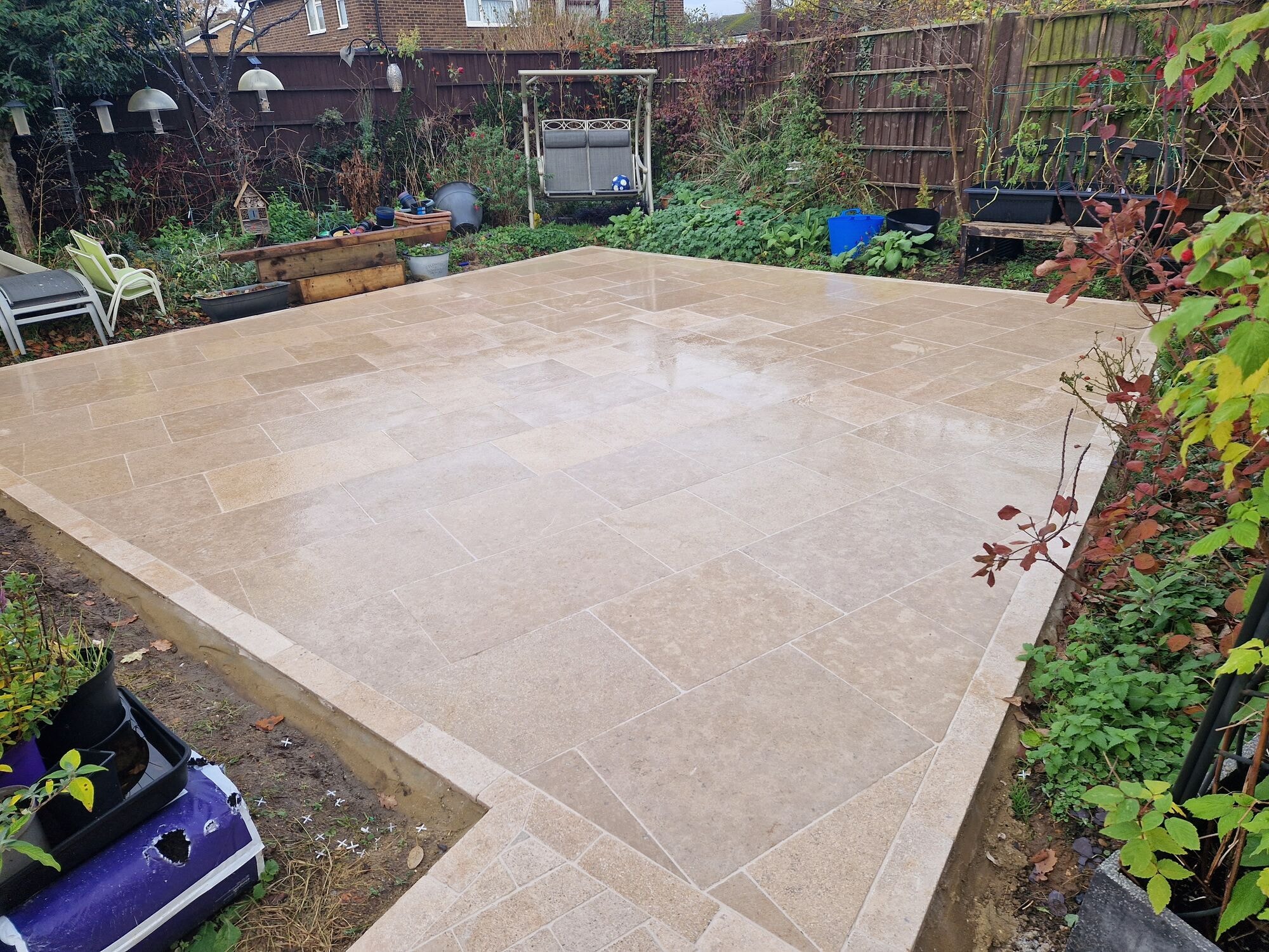 Wide view of the completed travertine patio laid to a clean block pattern by DNR Build