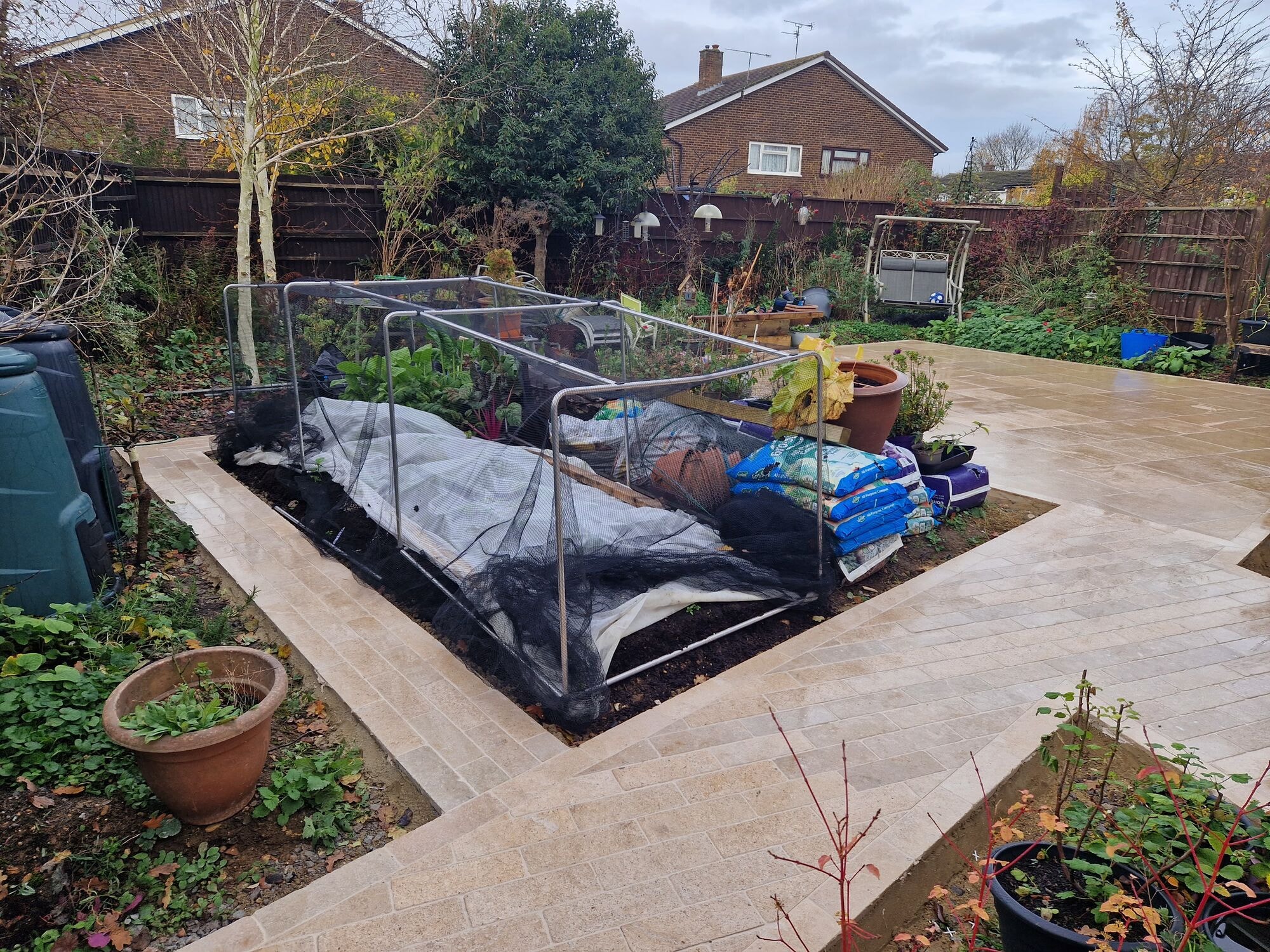 The finished patio sweeping around the garden borders with raised beds and planting by DNR Build