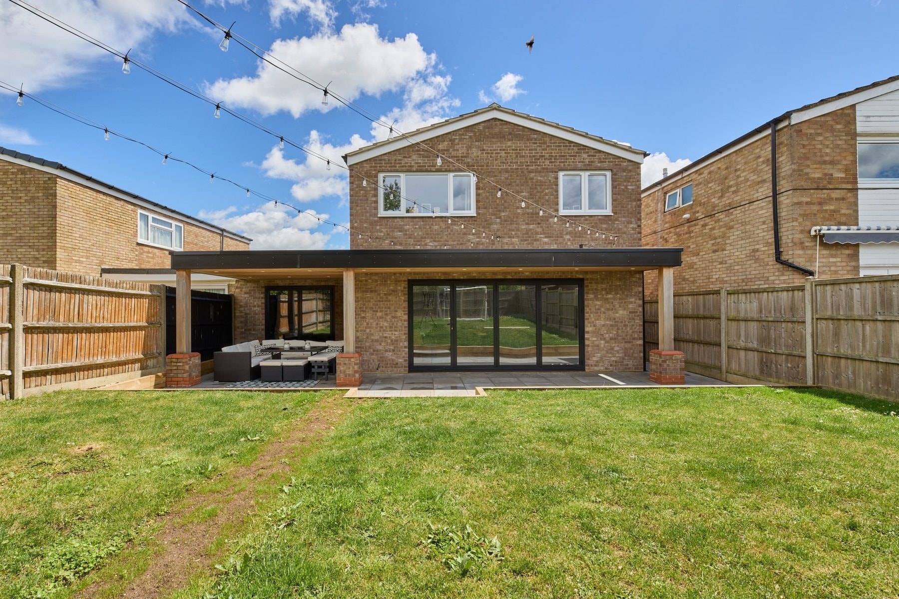 The same view after, with the new double storey rear extension, cedar canopy and bi-fold doors by DNR Build