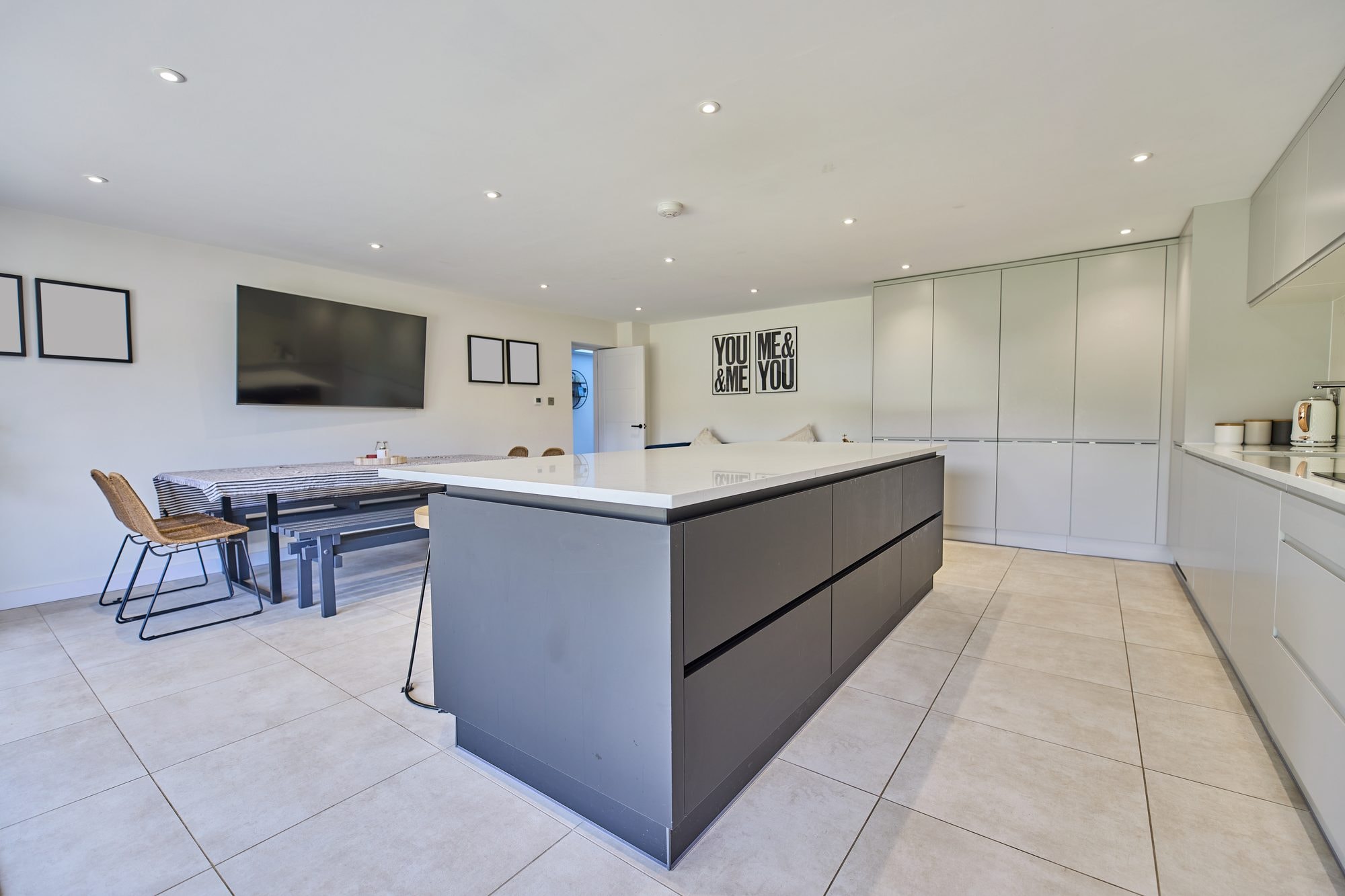 The finished open plan kitchen and dining room with a large island and bi-fold doors at the Stevenage home by DNR Build (3 of 6)
