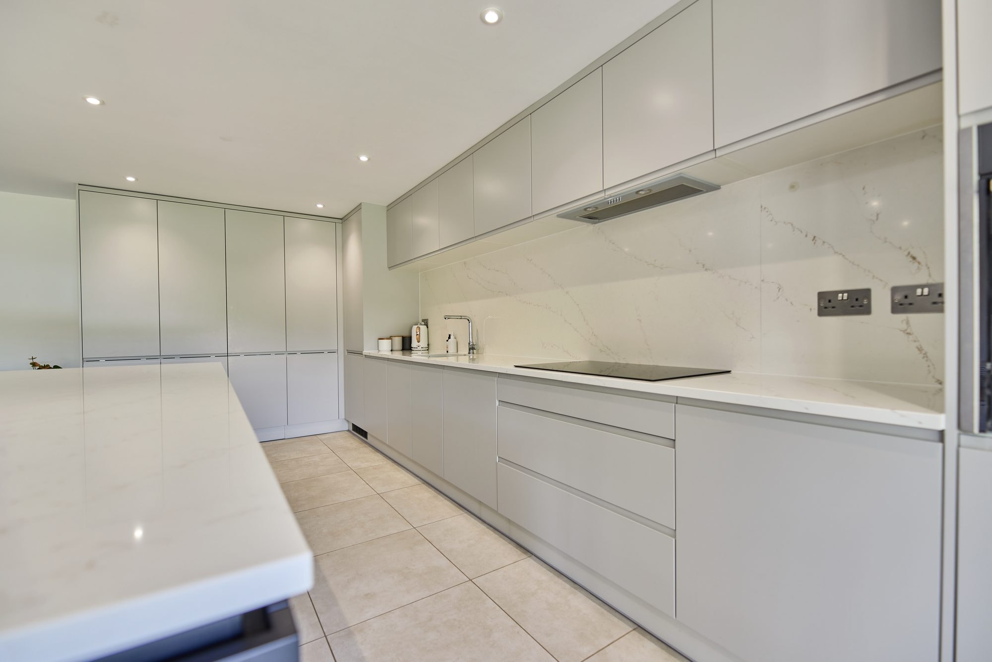 The finished open plan kitchen and dining room with a large island and bi-fold doors at the Stevenage home by DNR Build (5 of 6)