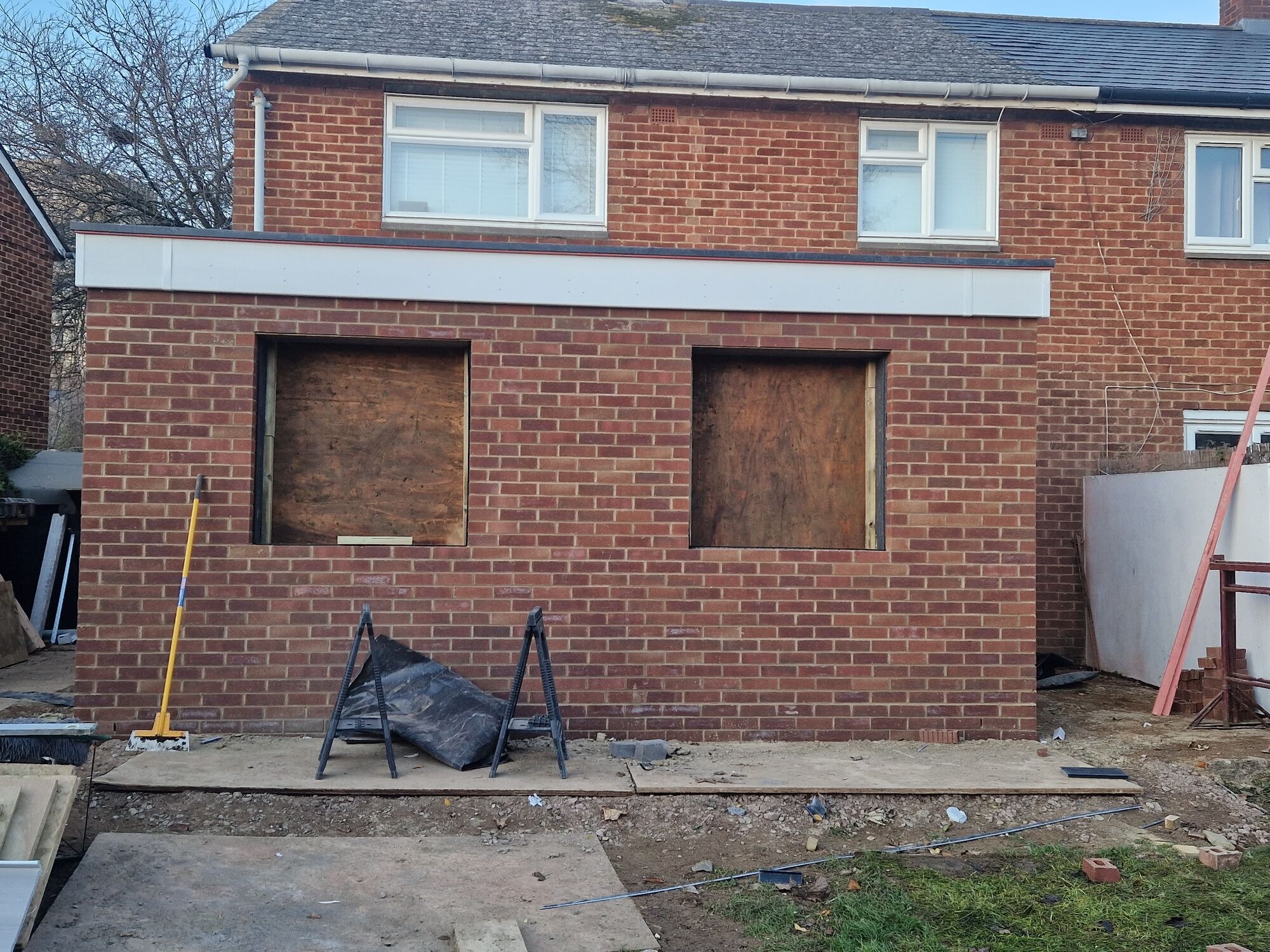 Completed brickwork with new lintels and window openings boarded ready for glazing by DNR Build