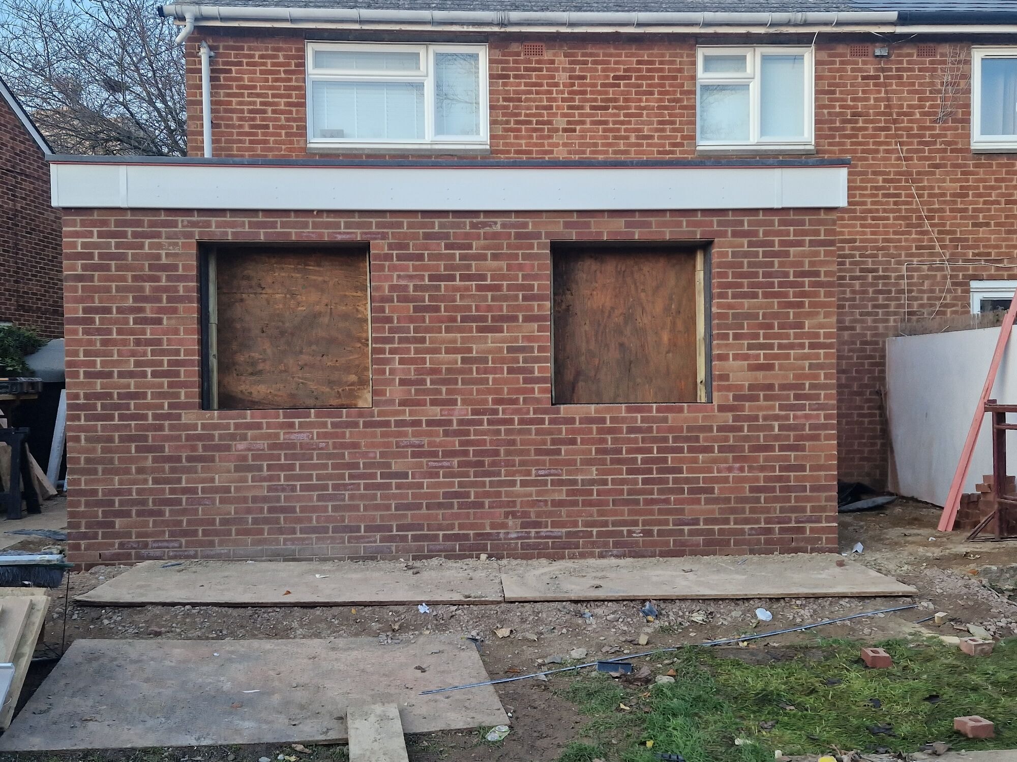 Front-on view of the finished brick shell with new flat roof and fascia on the extension by DNR Build