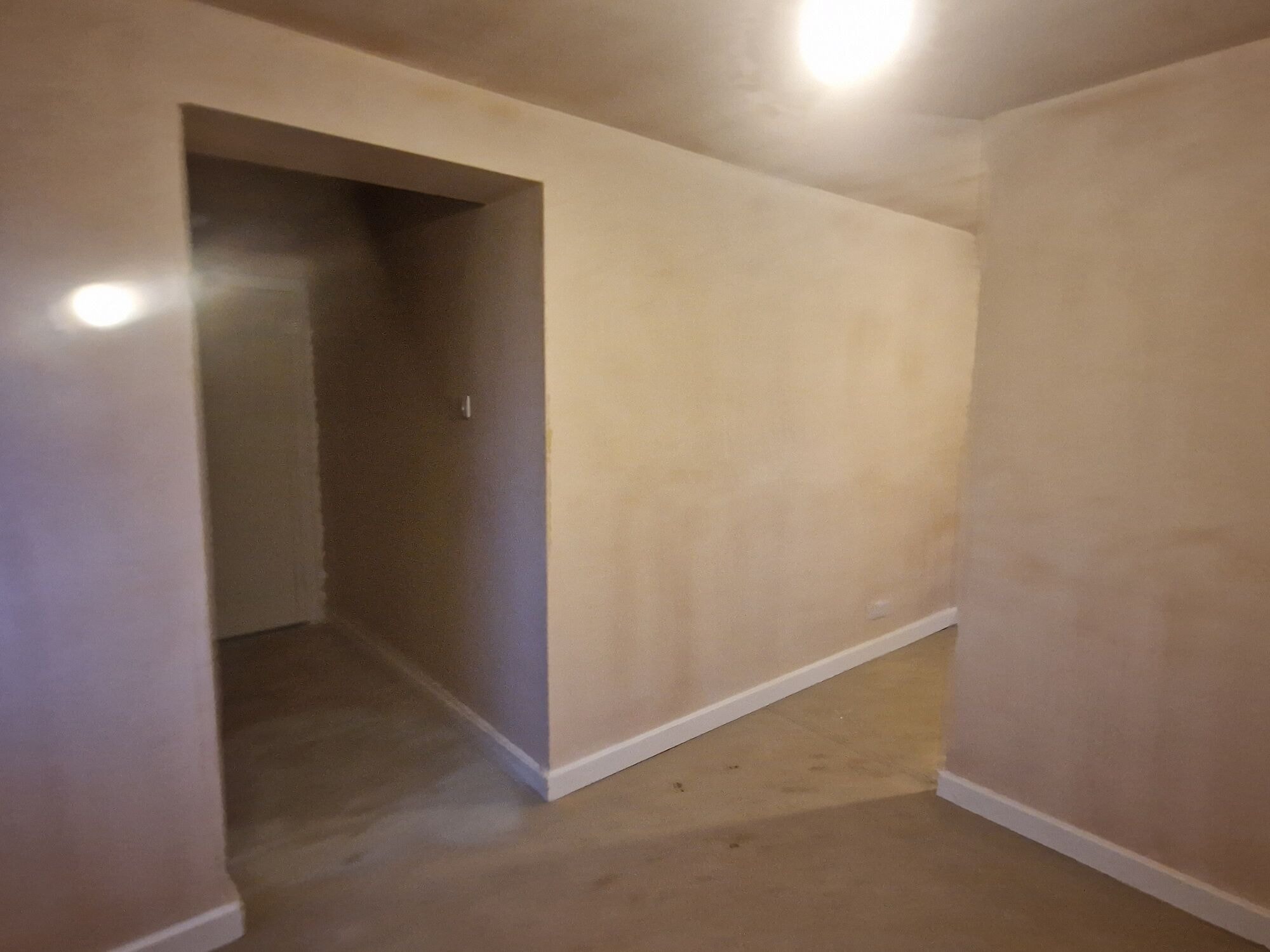Freshly plastered interior with a new opening through to the extension by DNR Build