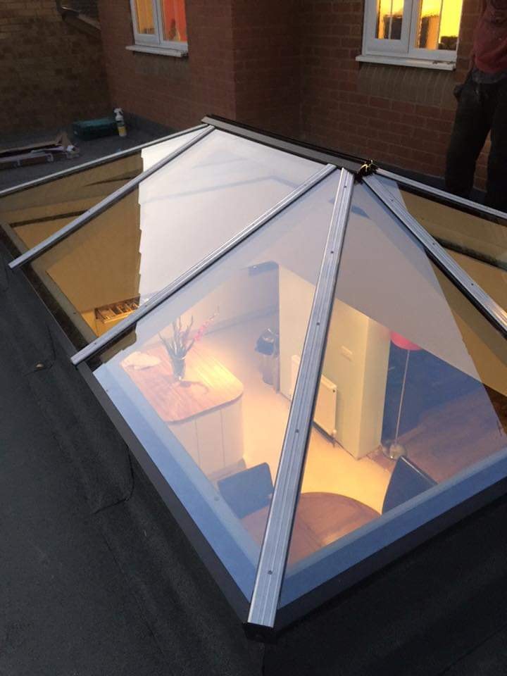 The roof lantern from outside at dusk looking down into the new kitchen below by DNR Build